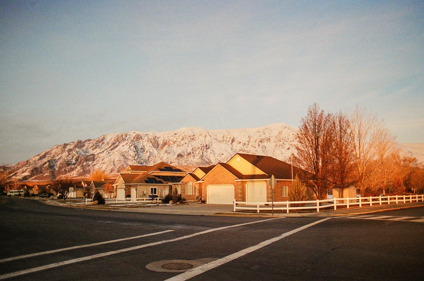 Homes beneath the Wasatch Mountains at sunset, illustrative